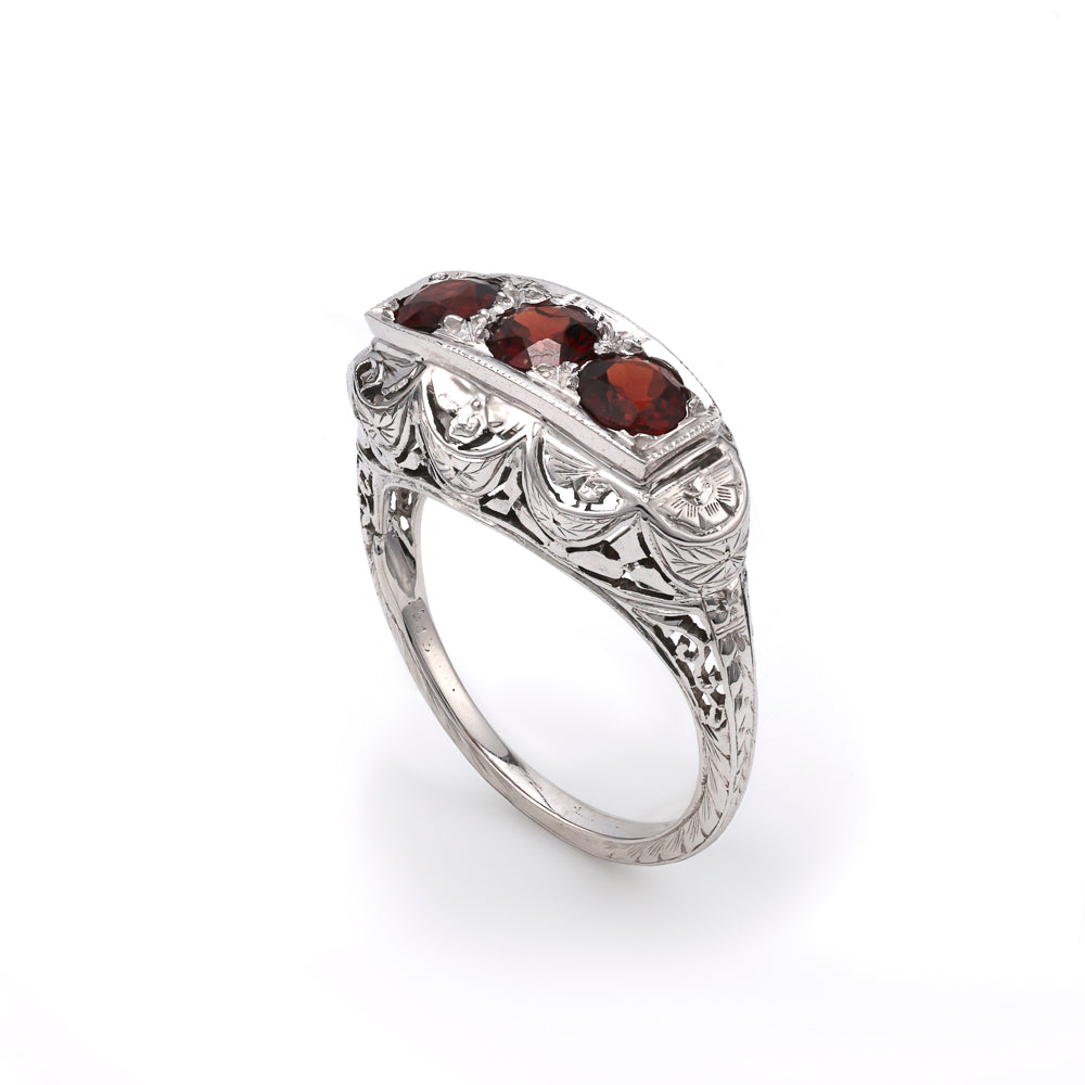 Three garnet ring in ornate white gold.