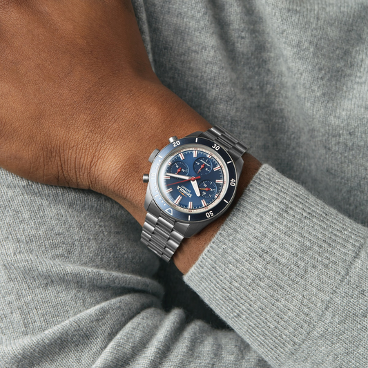 Blue dial titanium men's watch on wrist.