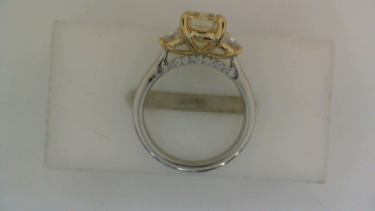 Three-stone engagement ring with yellow diamond.
