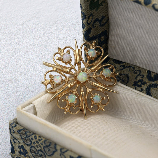 Starburst opal pin in yellow gold.