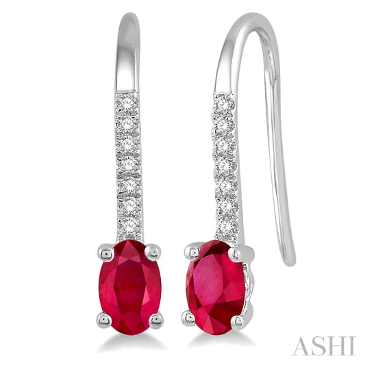 Oval ruby earrings with diamond accents.