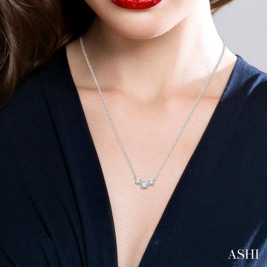 Diamond necklace with three round stones.