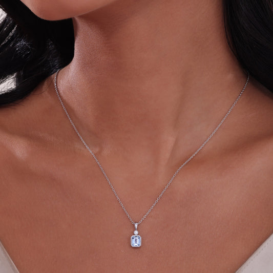 Emerald-cut aquamarine pendant on silver chain.