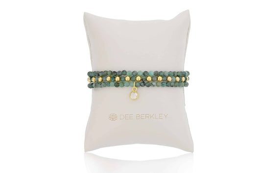 Emerald and gold stretch bracelet on display.