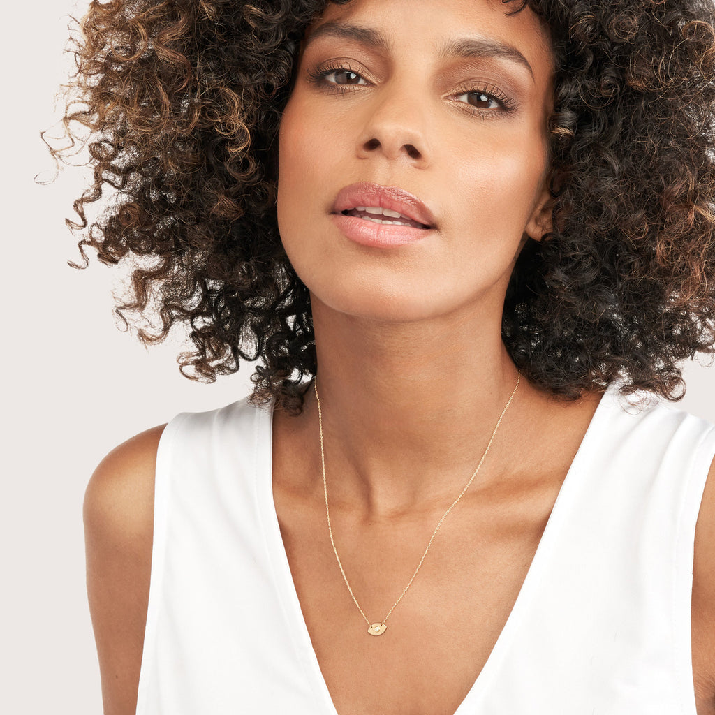 Yellow gold necklace with round diamond pendant.