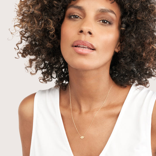 Yellow gold necklace with round diamond pendant.