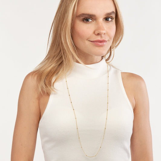 14K yellow gold station necklace on model.