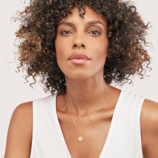 14K gold necklace with round diamond pendant.