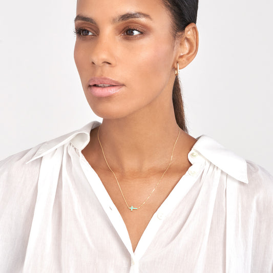 14K gold cross necklace on model.