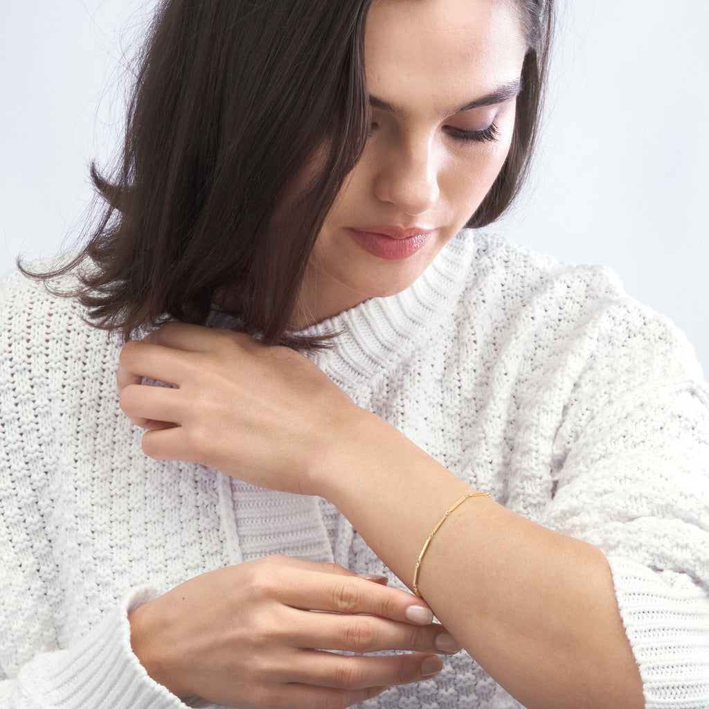 14K yellow gold minimalist bracelet worn.