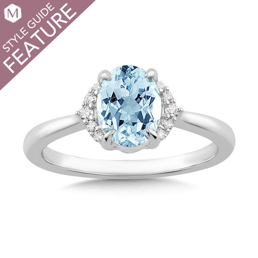 Oval blue topaz ring with diamond accents.