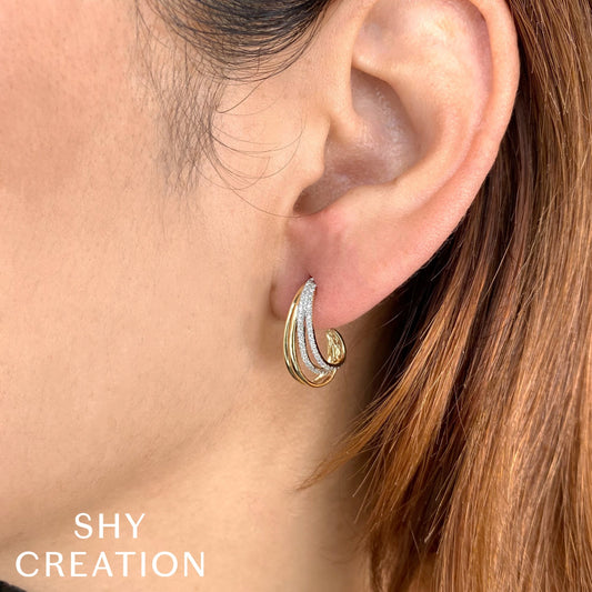 Gold and diamond J hoop earrings.