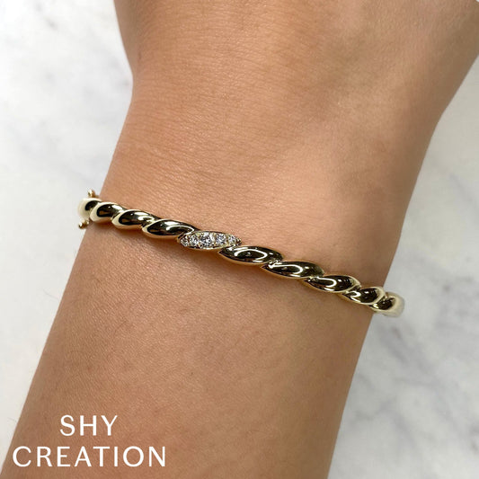 Yellow gold bangle with round diamonds.
