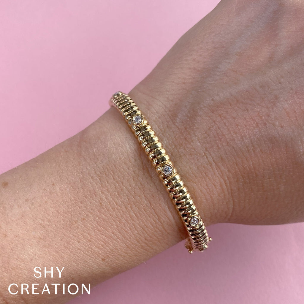 Gold bangle with round diamonds.