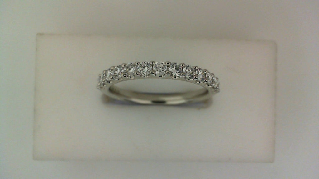 Angled front view of a white gold wedding band featuring a row of round diamonds in a shared-prong setting.