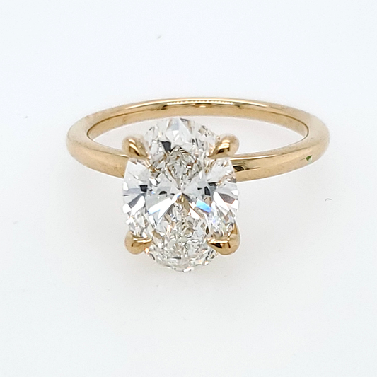 Front view of a yellow gold solitaire engagement ring featuring an oval-cut diamond in a four-prong setting.