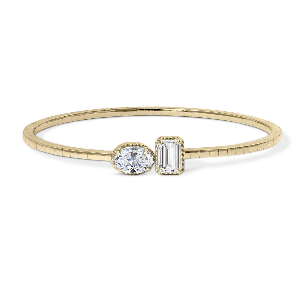 Gold cuff bracelet with oval, emerald diamonds.