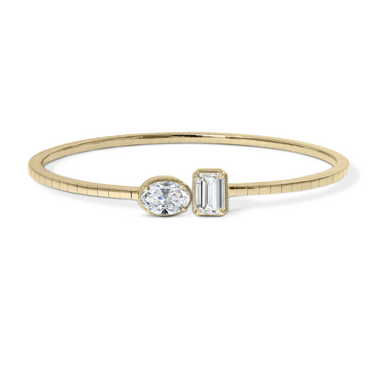 Gold cuff bracelet with oval, emerald diamonds.