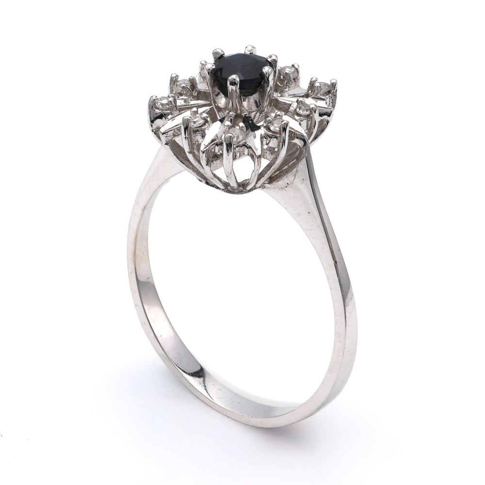 18K white gold ring with sapphire centerpiece.