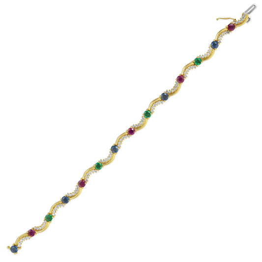 Curved gold bracelet with rubies, emeralds, sapphires.