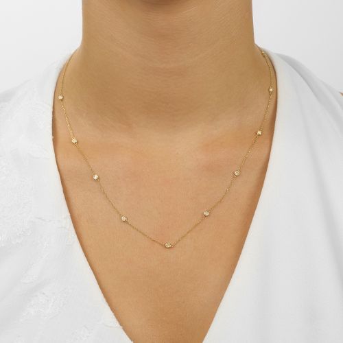 Diamond necklace in yellow gold on model.
