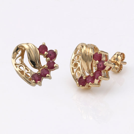 Heart-shaped gold earrings with round rubies.