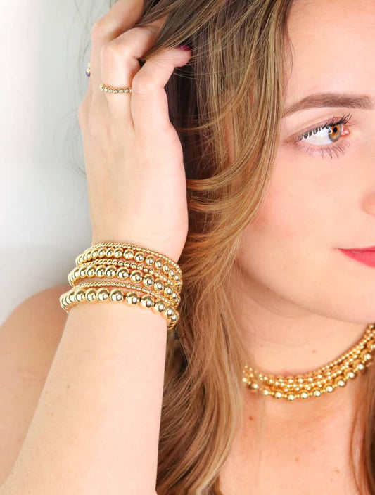 Gold-filled bead necklace on woman's neck.