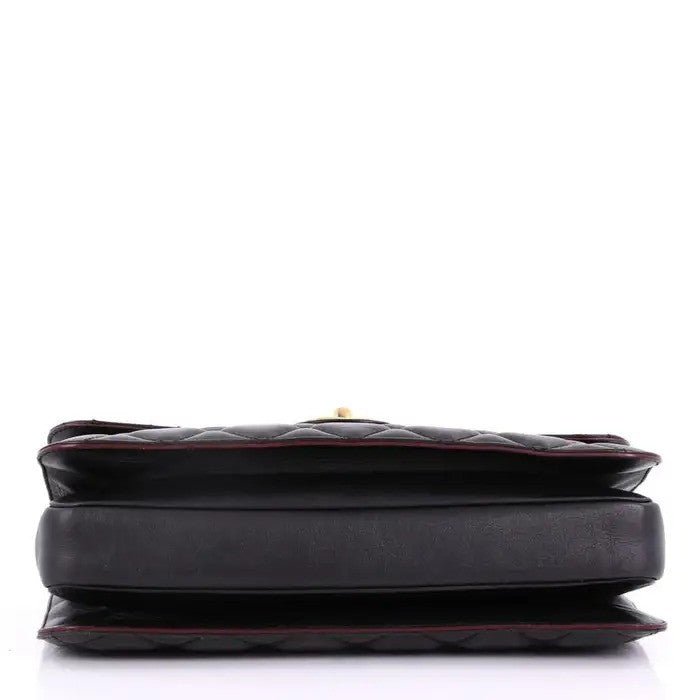 Black quilted leather handbag with yellow hardware.