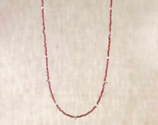 Sterling silver necklace with round garnet beads.