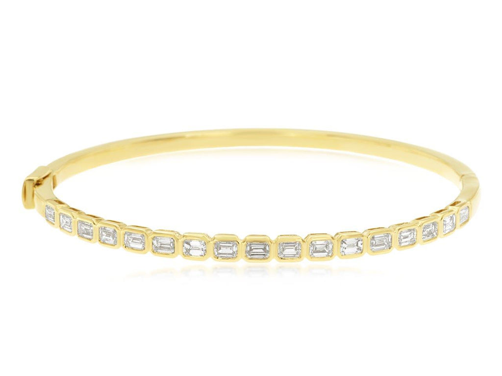 Yellow gold bangle with emerald-cut diamonds.