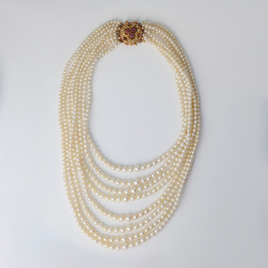 Multi-strand pearl necklace with gemstone clasp.