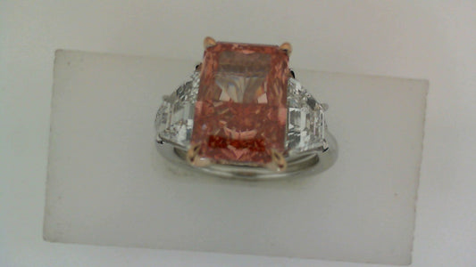 Pink radiant diamond ring with trapezoid accents.