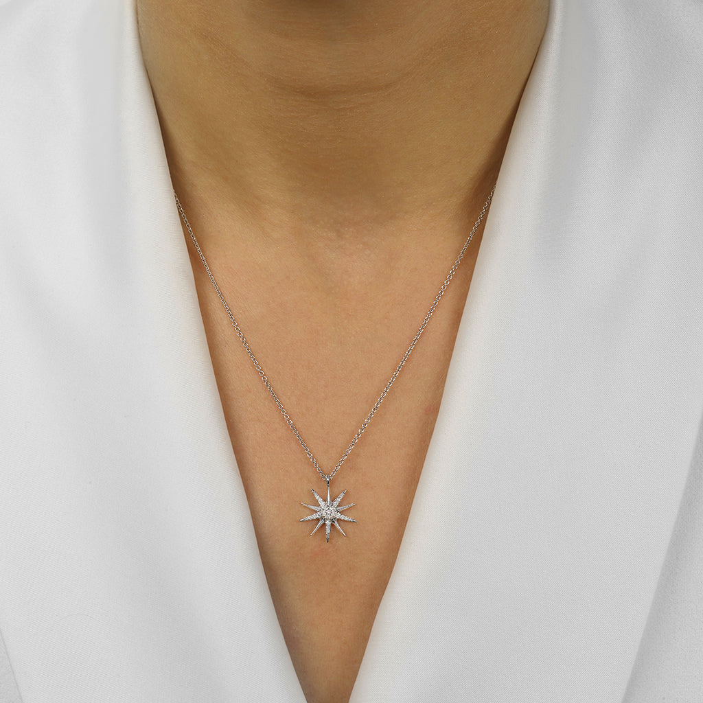 Starburst diamond pendant on silver necklace.