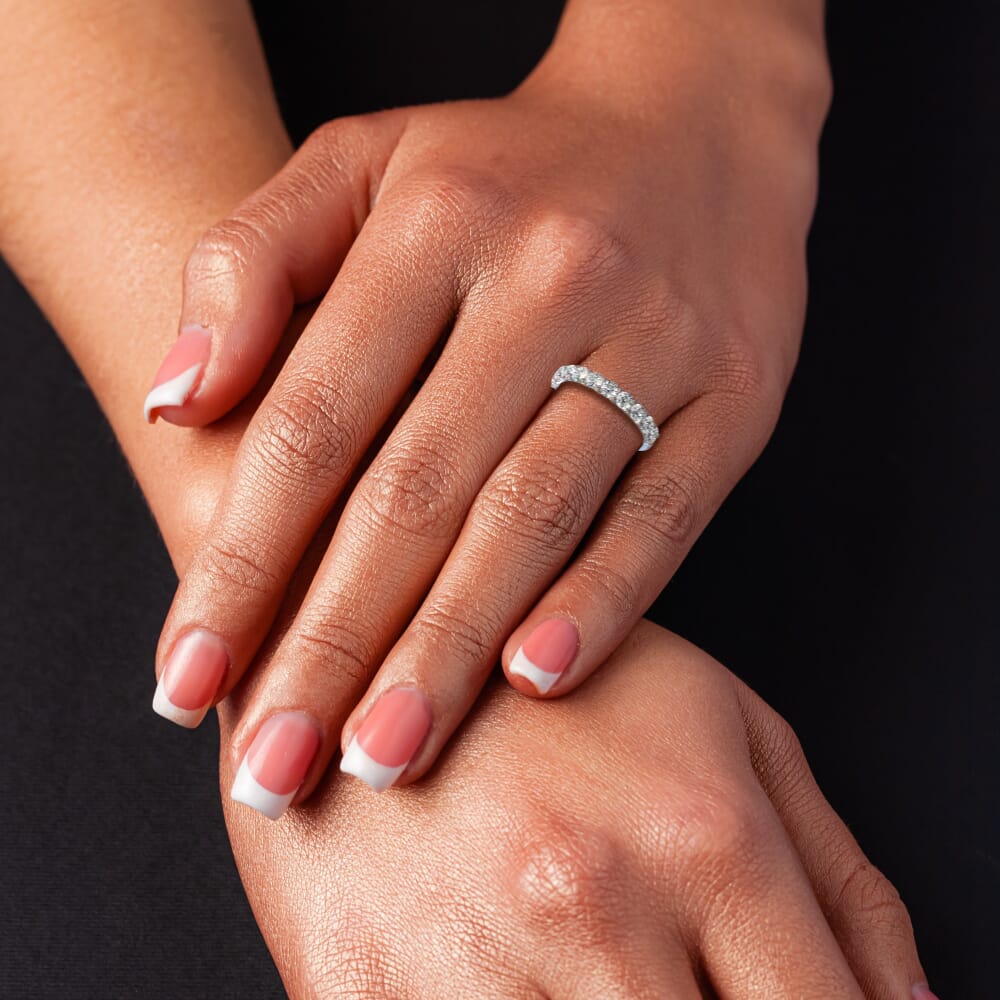 Platinum diamond band on manicured hand.