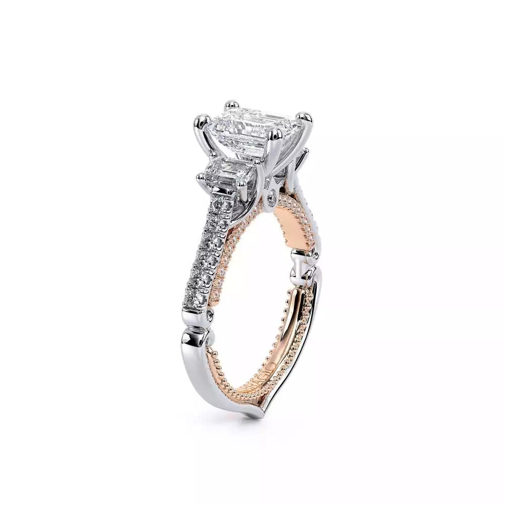 Three-stone diamond ring with emerald accents.