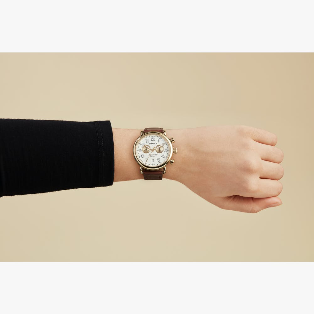Champagne dial watch with leather band.