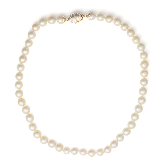 Cream pearl necklace with gold diamond clasp.