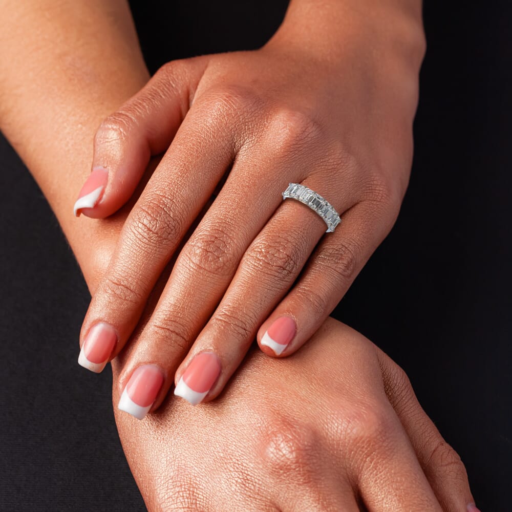 Emerald diamond wedding band on hand.