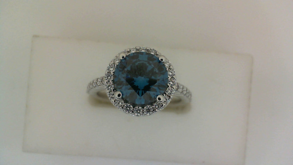 Blue diamond halo engagement ring in white gold.