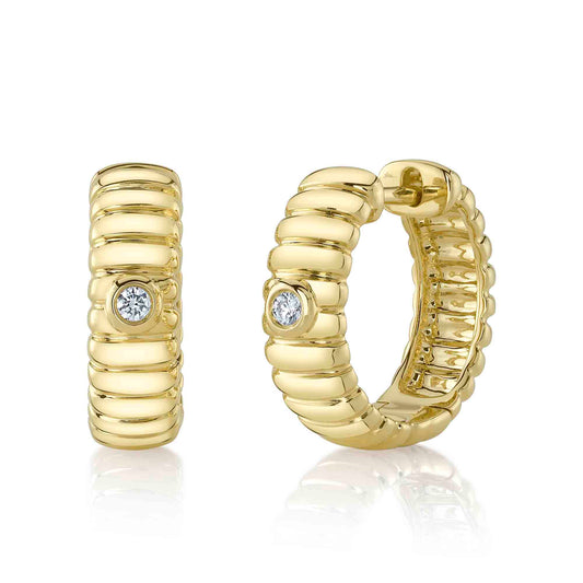 Gold huggie earrings with round diamonds.