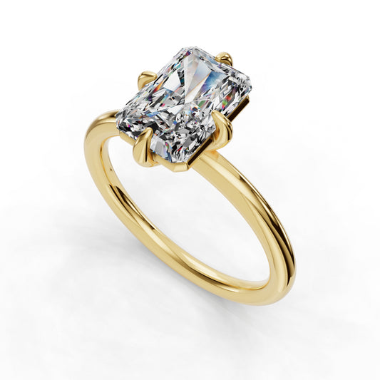 Emerald-cut diamond on gold band ring.