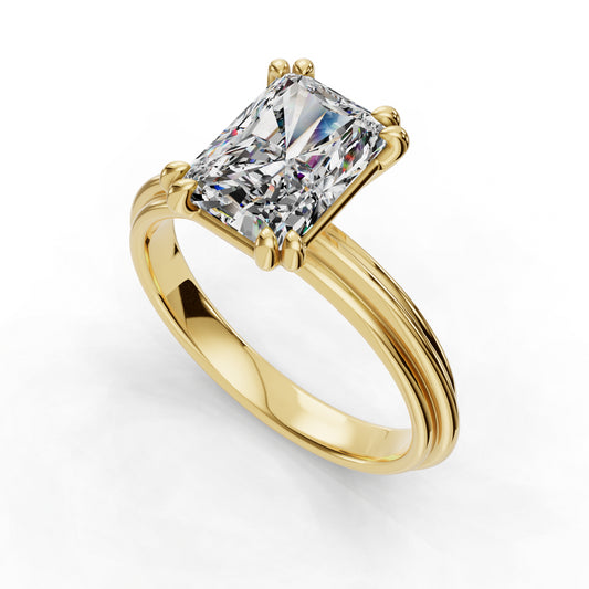 Radiant-cut diamond on gold band ring.