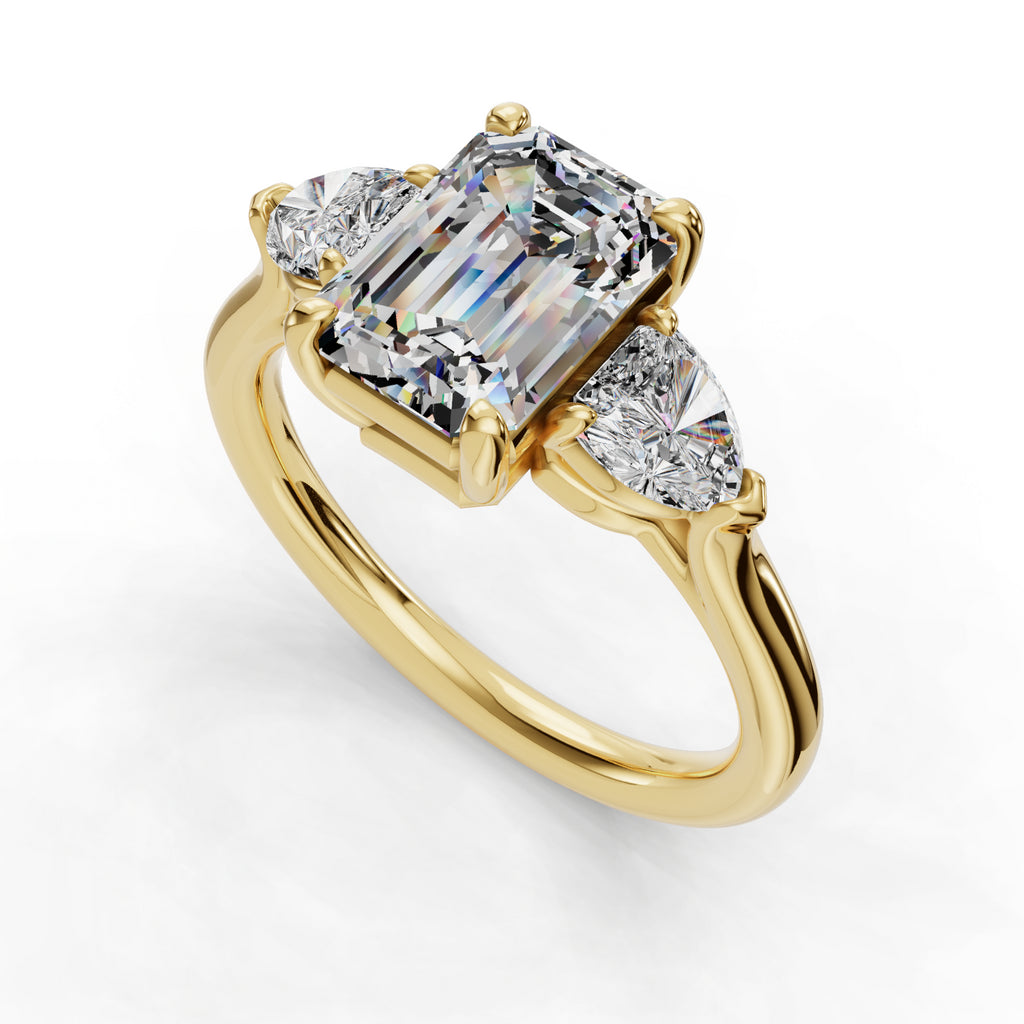 Gold ring with emerald-cut and pear diamonds.