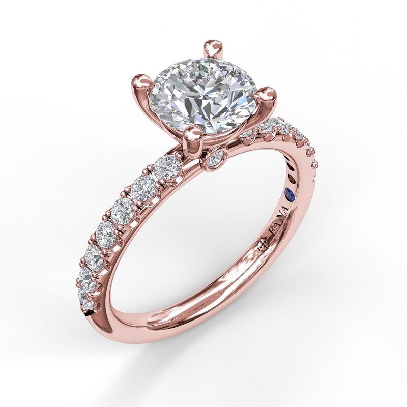 Rose gold diamond engagement ring with sapphire accent.