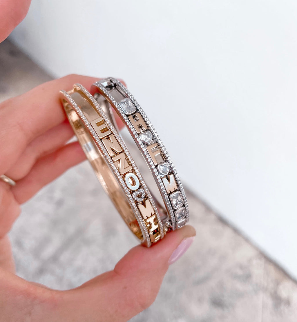 Gold and silver charm bangles with letters.