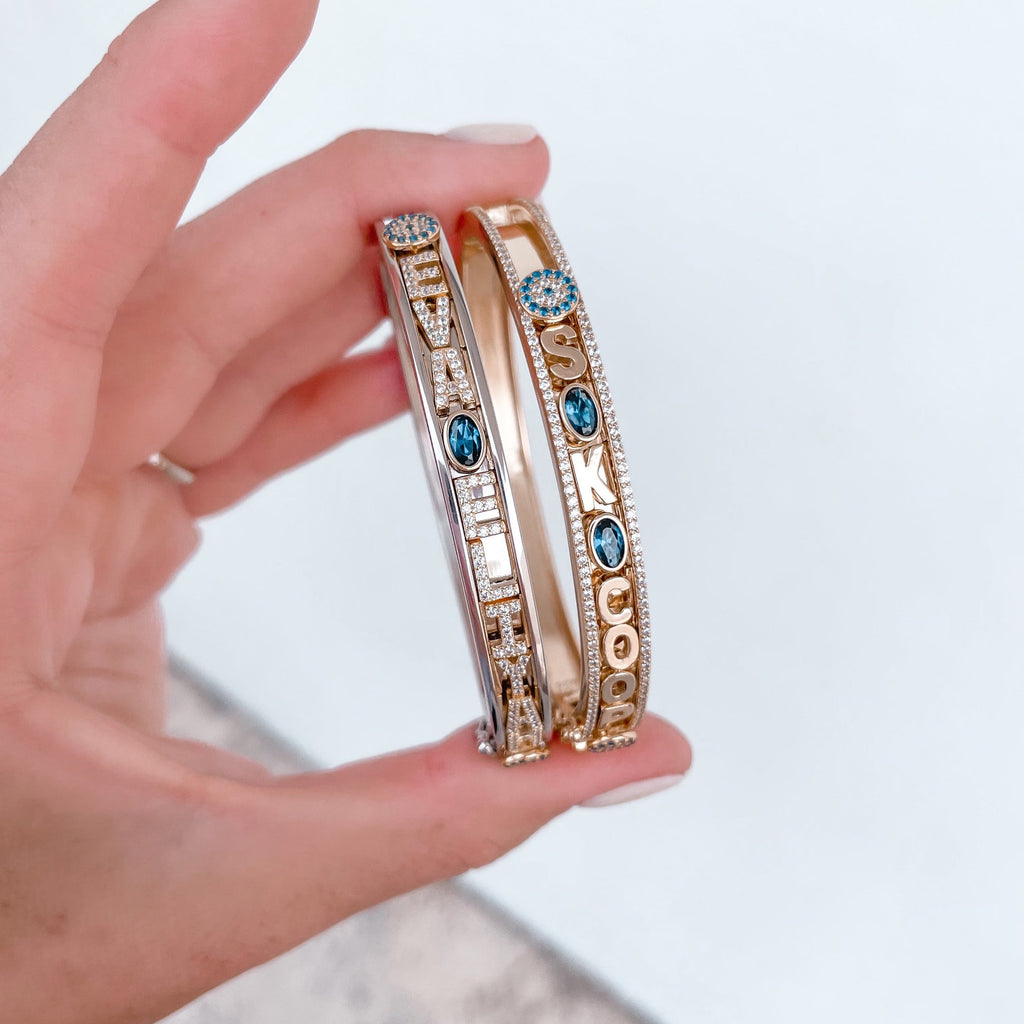 Gold bangle with blue gemstone charms.
