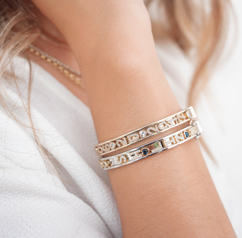 Gold charm bangle with alphabet charms.