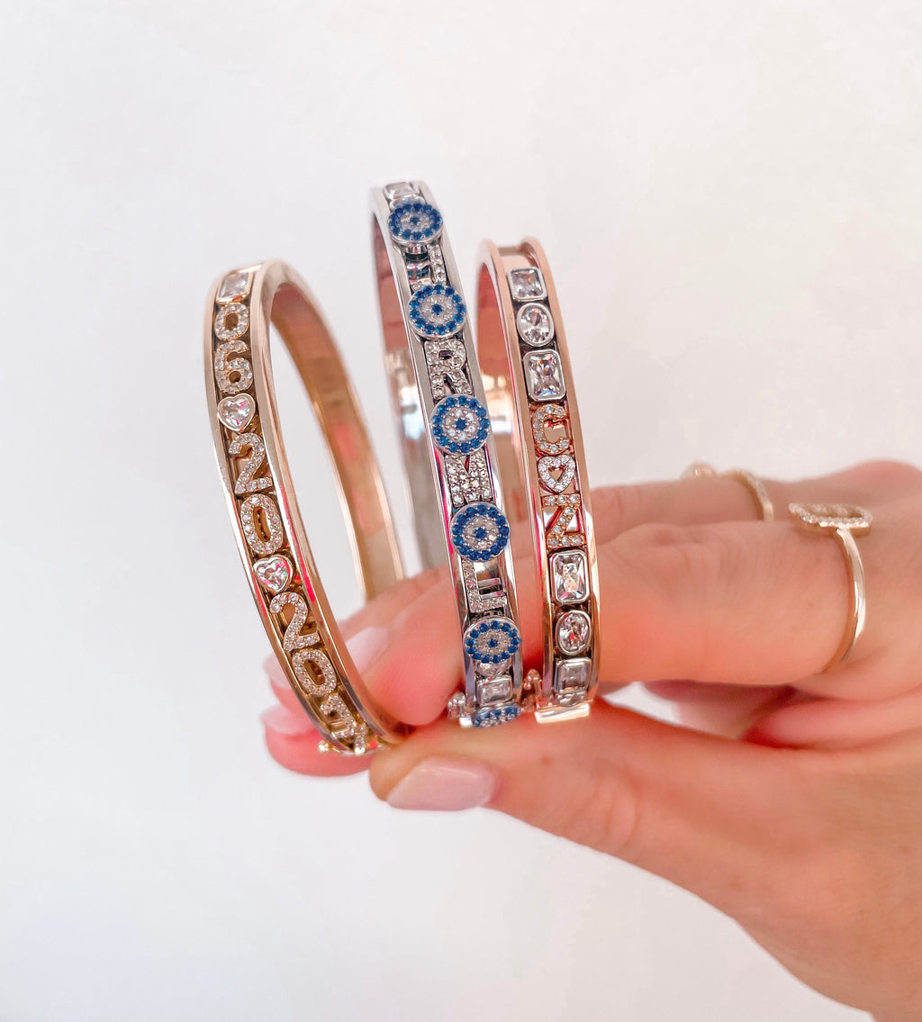Gold and silver charm bangles with letters.