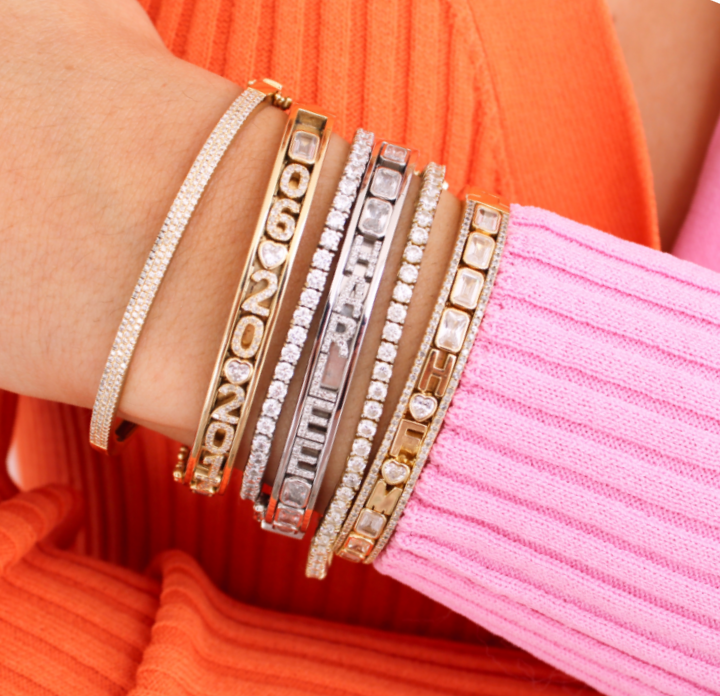 Gold and silver charm bangles stacked.
