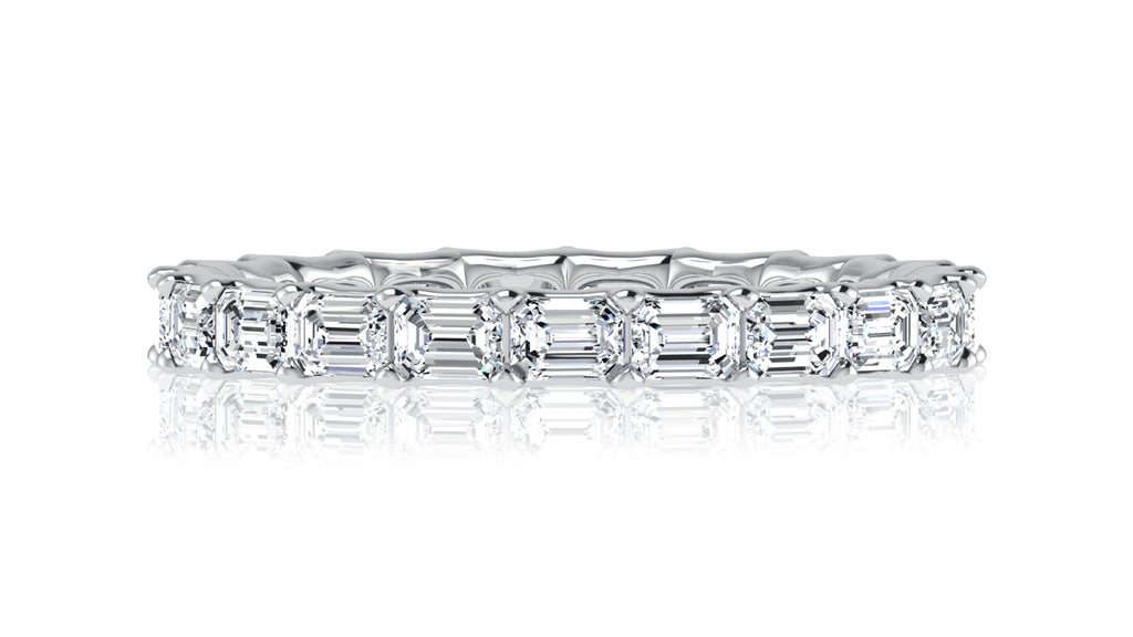 East-west emerald cut diamond band in white gold.